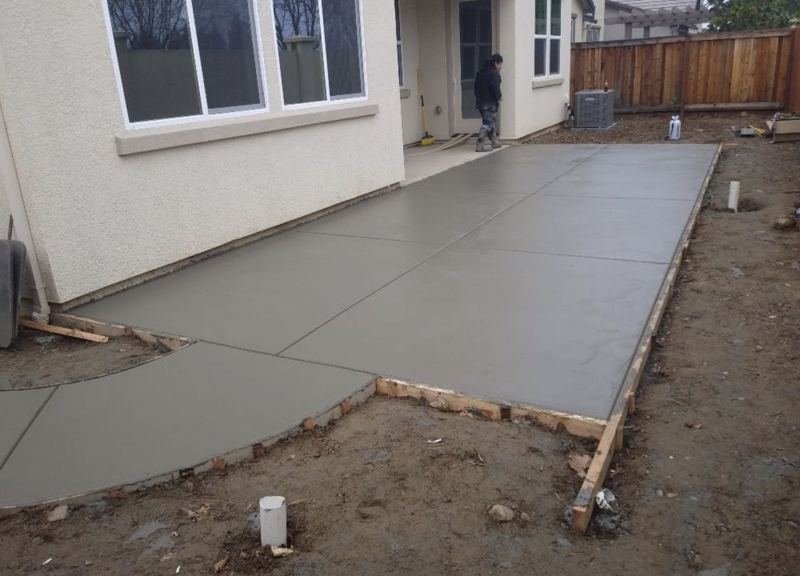 New concrete patio wrapping the back of a house