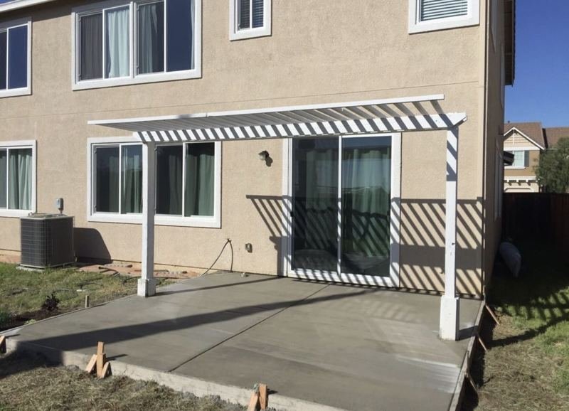 White pergola over a new concrete patio