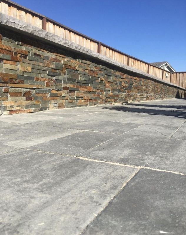 Stacked stone wall over a slab patio